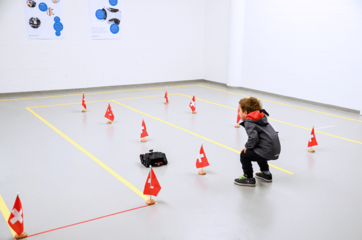 Kids are navigating the robot through a parcours, having a lot of fun along the way.