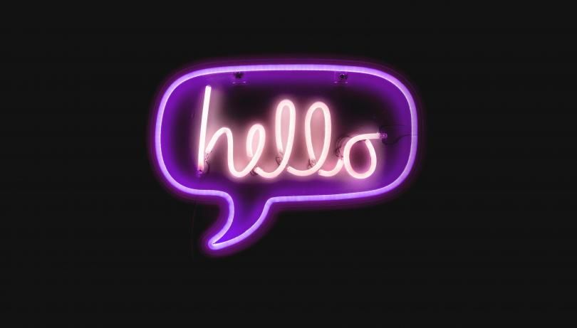 Neon letters forming the word "Hello" in a speech bubble.
